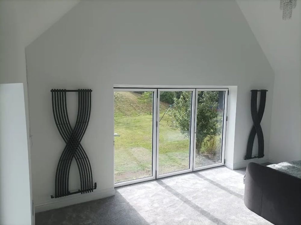 Two anthracite designer vertical radiators either side of bifold doors
